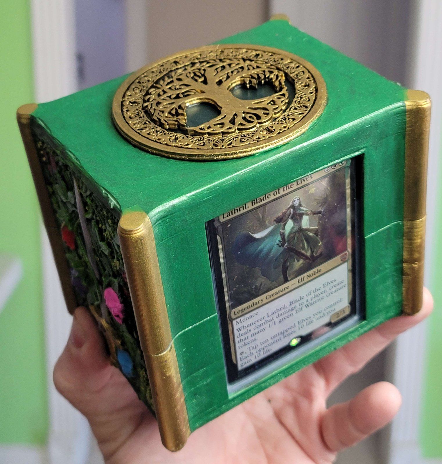 The forest deck box’s lid, with a gold Tree of Life medallion, above the card window