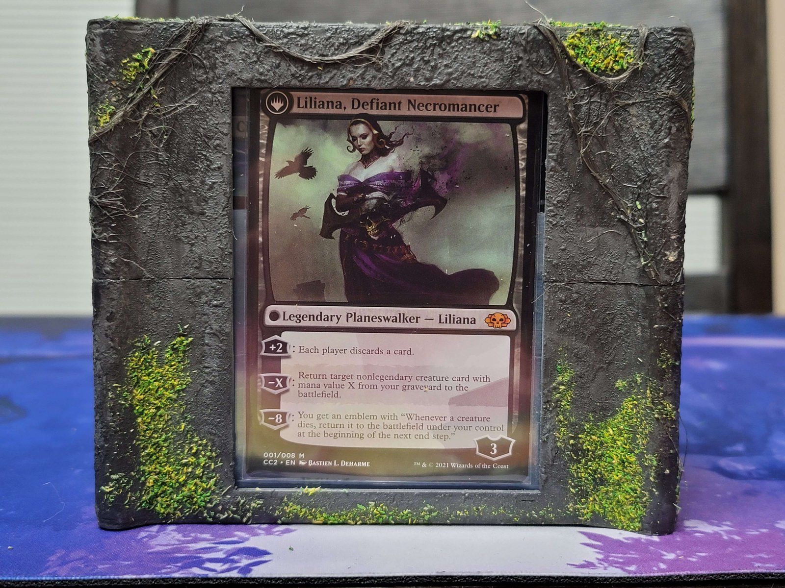 The stone deck box’s window, framing a Liliana card