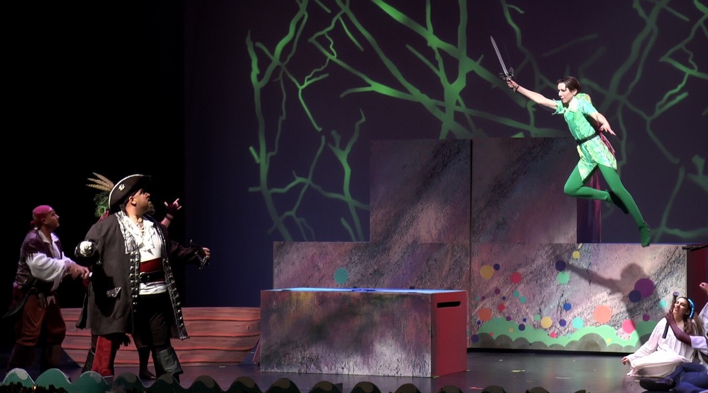 Captain Hook and his crew on stage as Peter Pan flies overhead